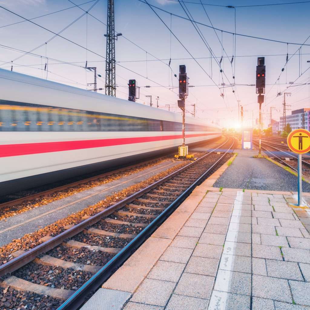 High speed train in motion on the railway station at sunset